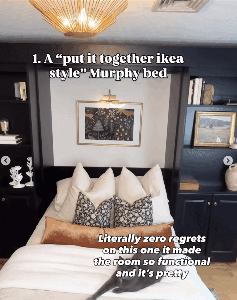 Black built-in Murphy bed open with cozy bedding, throw pillows, and wall art, showcasing a functional space-saving guest room design.