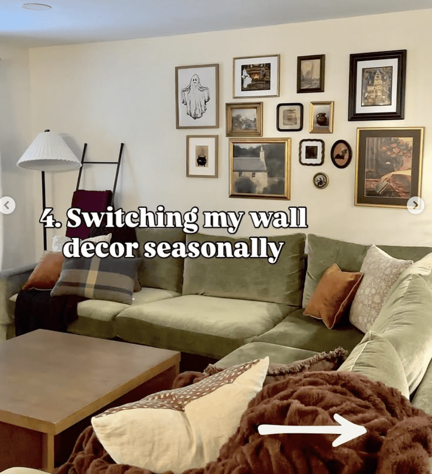 Cozy living room with green sectional and a seasonal gallery wall featuring gold and black frames with autumn-themed artwork. Warm, inviting, and adaptable wall decor idea.