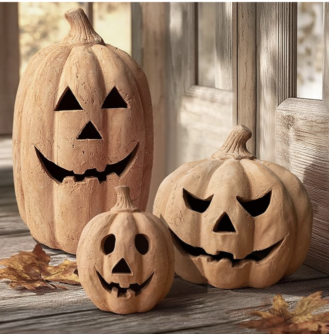 Three terracotta pumpkins carved as jack-o-lanterns