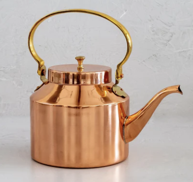 Shiny copper kettle with golden handle