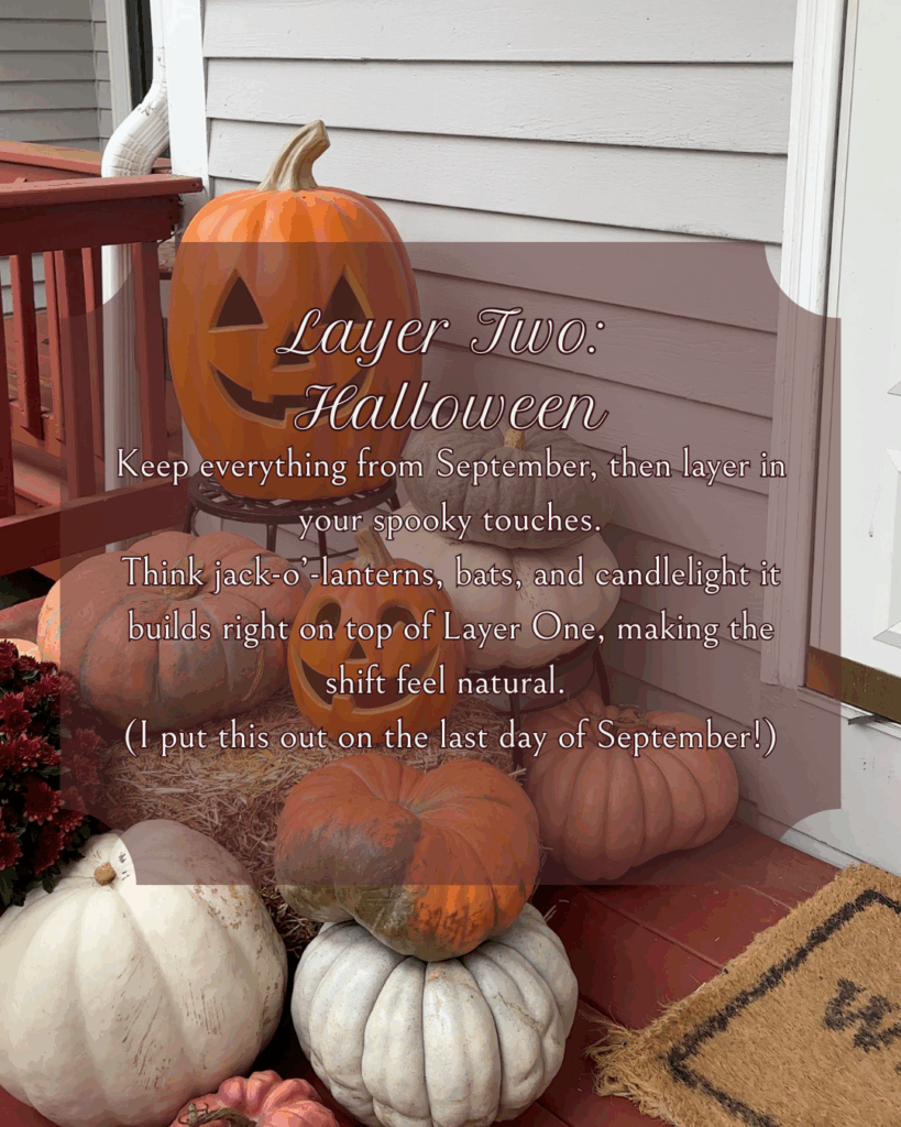 Porch decorated with stacked pumpkins and a jack-o’-lantern for Halloween. Layer Two adds spooky seasonal touches like candlelight and bats on top of early fall decor. Text overlay reads “Layer Two: Halloween.”
