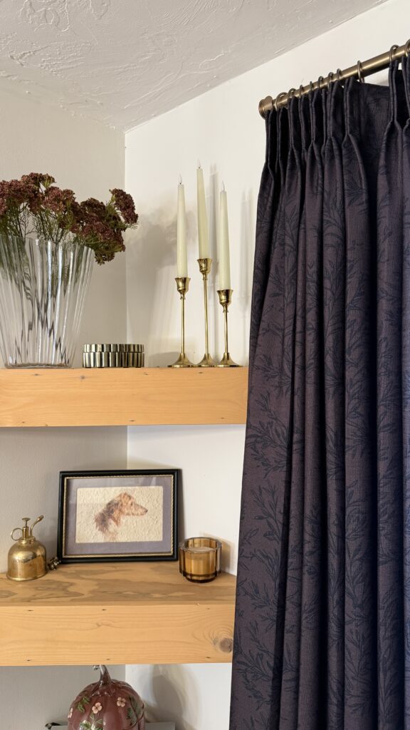 Elegant burgundy curtains with decorative shelf items