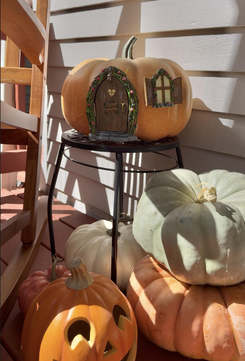 a faux pumpkin with a fairy door and window.