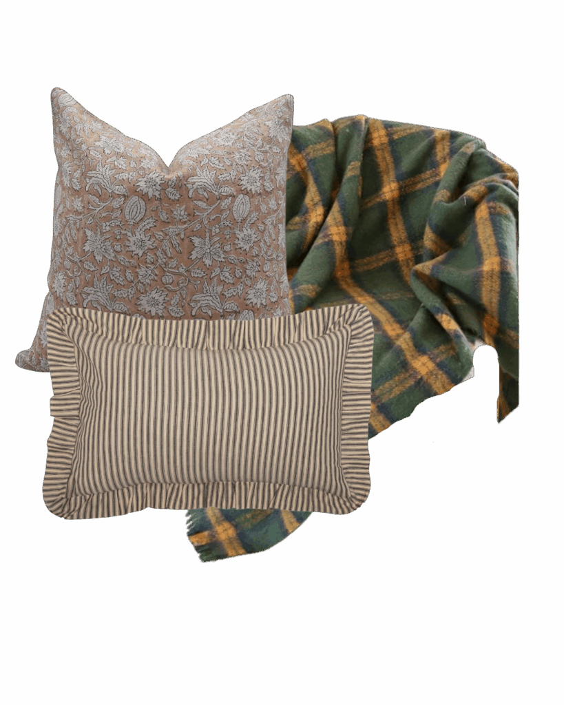 A layered cozy cabin-inspired set featuring a green and mustard plaid throw, a taupe floral pillow, and a ticking stripe ruffle pillow perfect for rustic fall decorating.