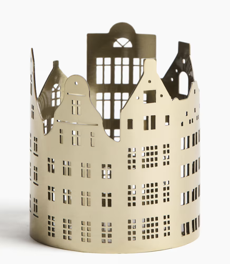 Gold metal Christmas village tea light holder from H&M Home featuring cut-out townhouse silhouettes that glow beautifully when a candle is lit inside — perfect for cozy holiday decor and mantle styling. Gold Christmas Decor.