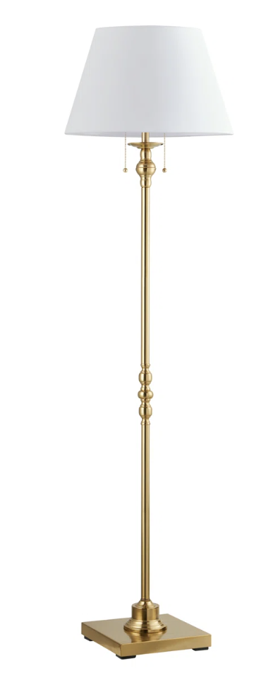 Brass Amiya 61-inch floor lamp in a cozy living room, providing warm ambient lighting and traditional decor charm.