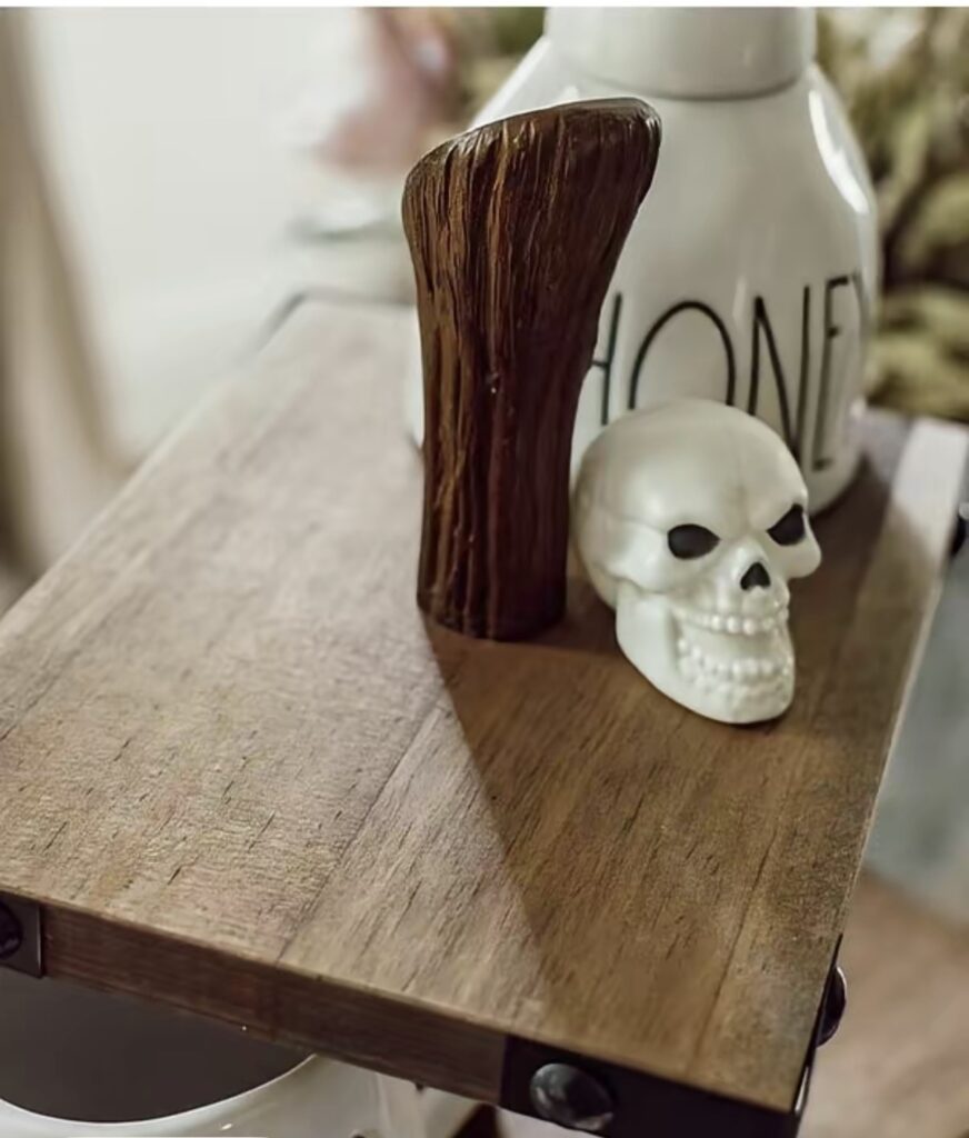 Top tier of a witch broom tiered tray styled with a mini skull
