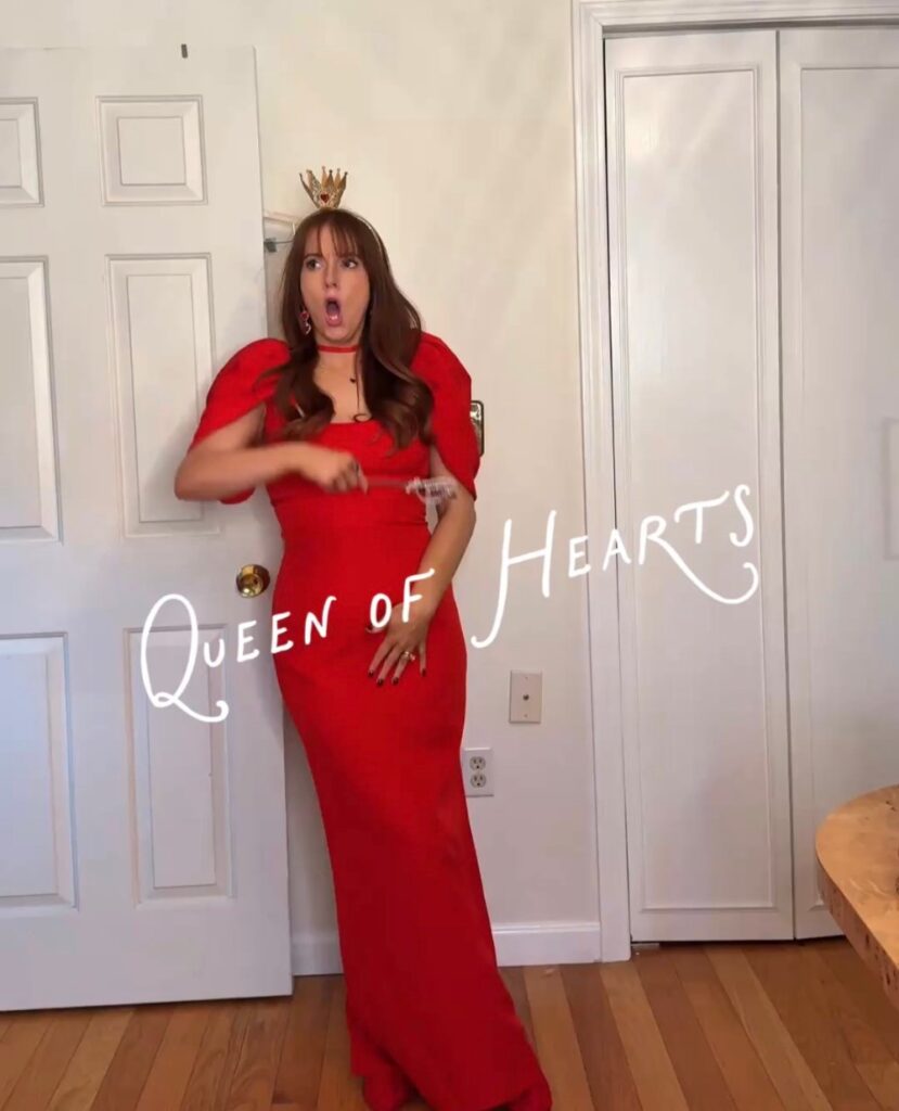 Queen of Hearts Halloween costume with a rented red puff sleeve gown from Rent the Runway, a crown and heart earrings