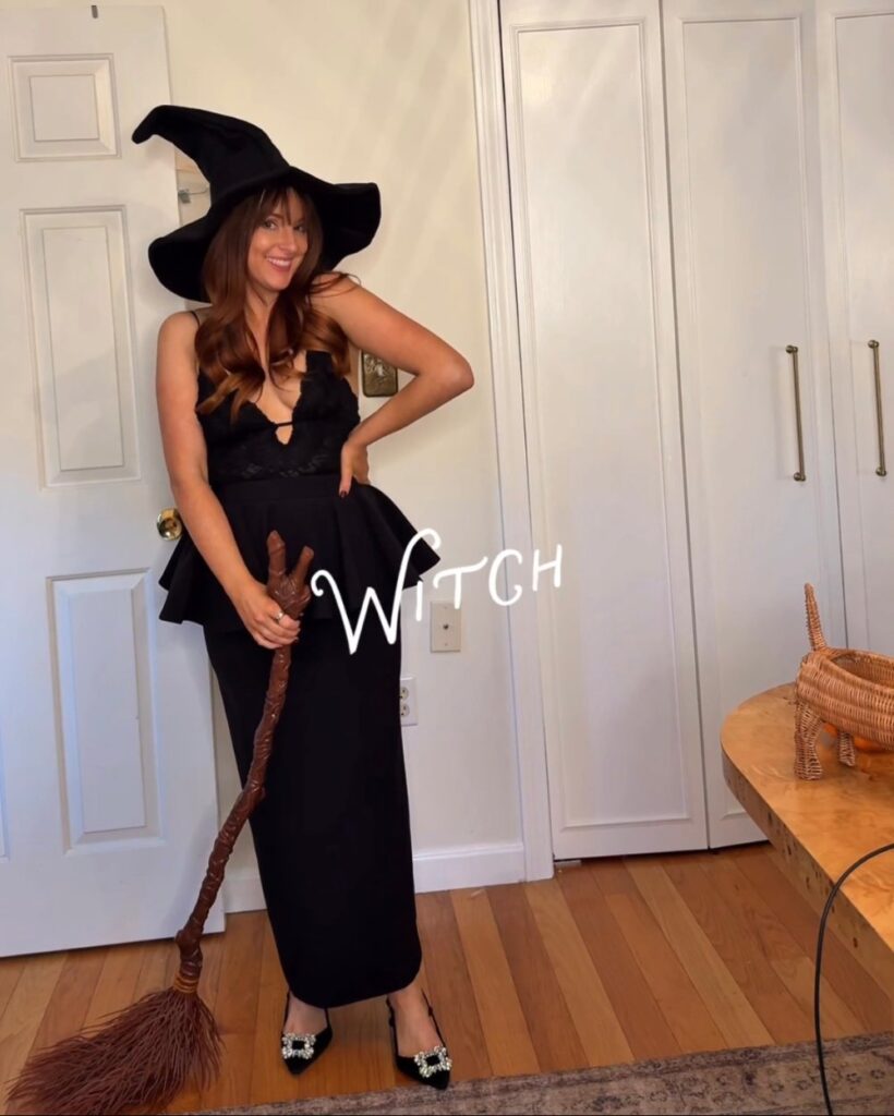 witch Halloween costume with a rented black lace and peplum look from Rent the Runway, a witch hat and a broom